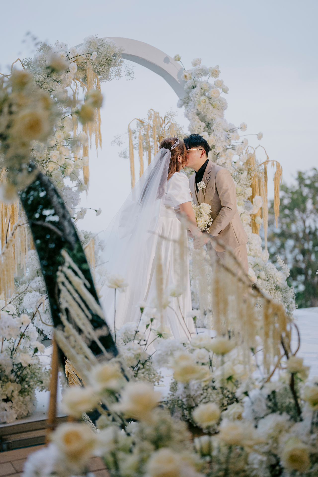 Floral arch ceremony kiss