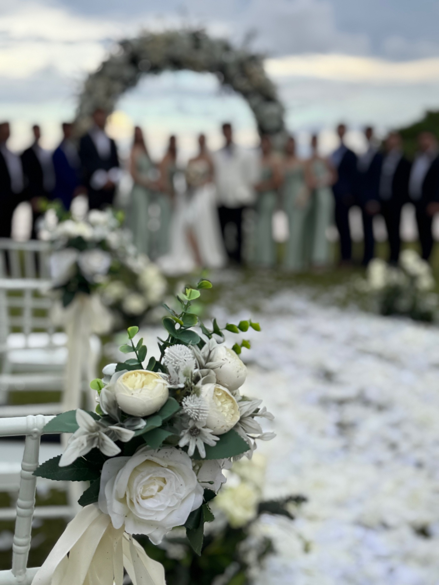 Bridal party at floral wreath arch ceremony