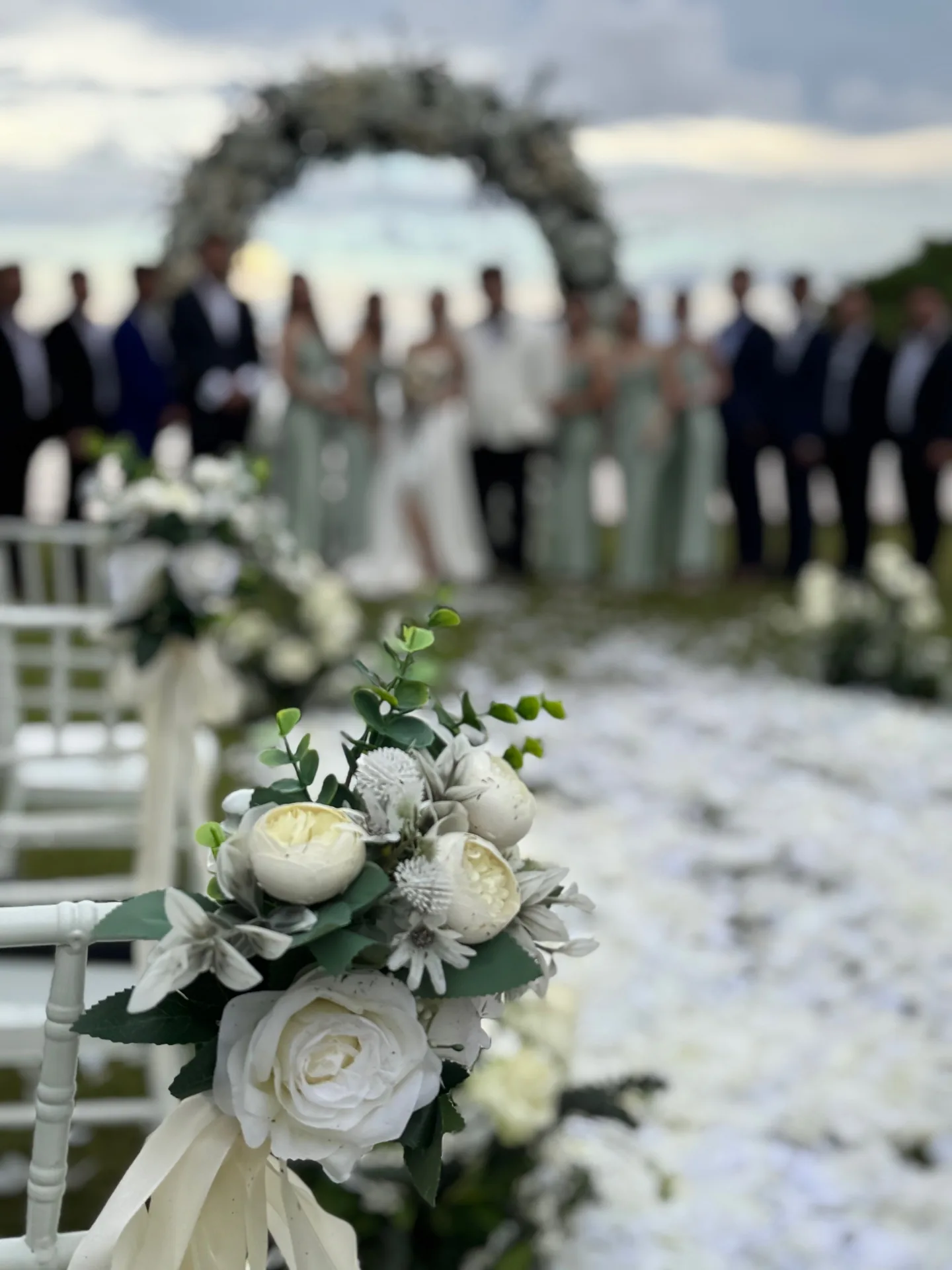 Bridal party at floral wreath arch ceremony