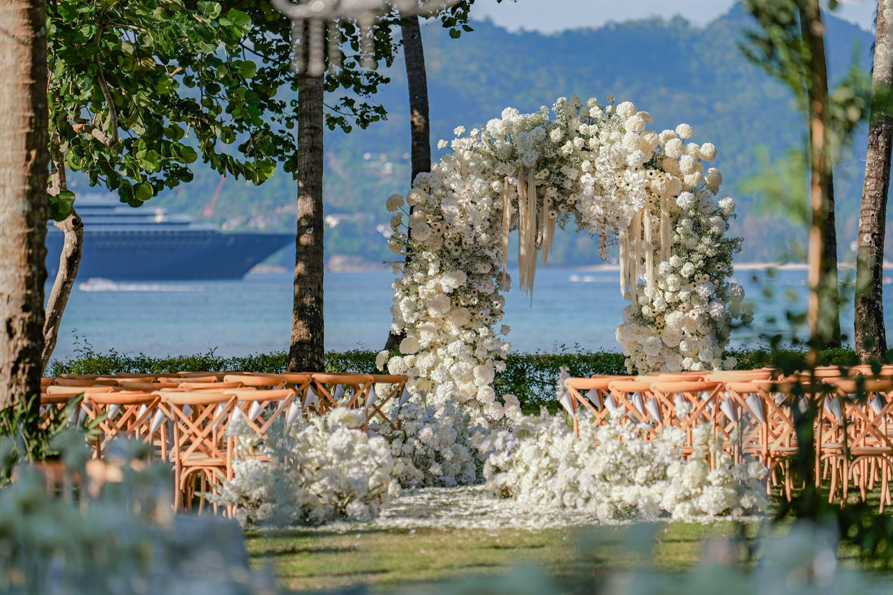 Seaside white floral arch ceremony with ocean view